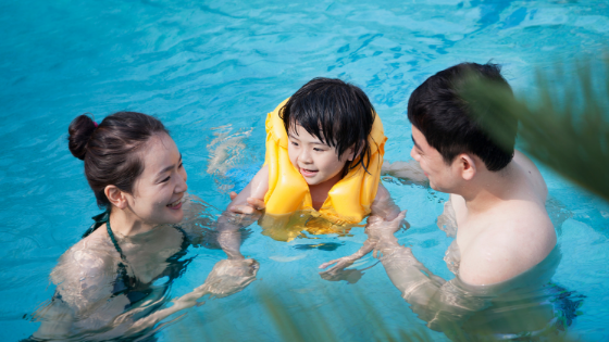 mother, father, and small child swimming