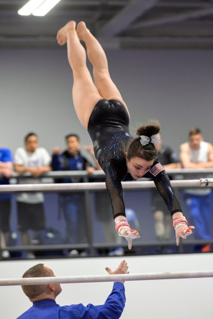 gymnast on uneven bars with coach Providence Moms Blog