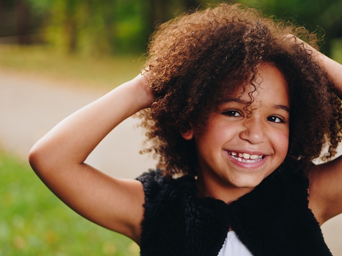 young girl with curly hair smiling Providence Moms Blog
