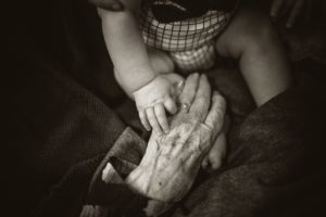 baby holding grandmother's hand