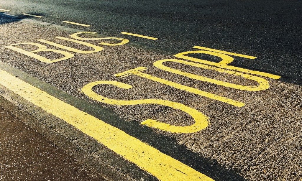 bus stop written on street in yellow paint