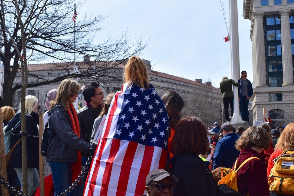 Woman wrapped in American Flag at a protest Providence Moms Blog