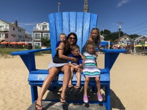photo of mom and 4 children in giant chair at beach