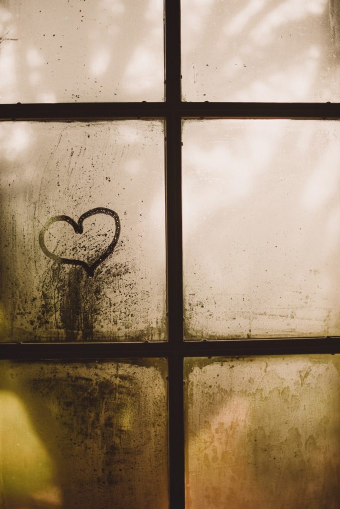 Dirty windowpane with heart shape sketched onto it. Providence Moms Blog article on children's feelings.