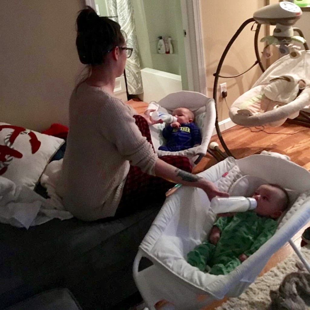 white mother feeds bottles to her twins in sleep rockers