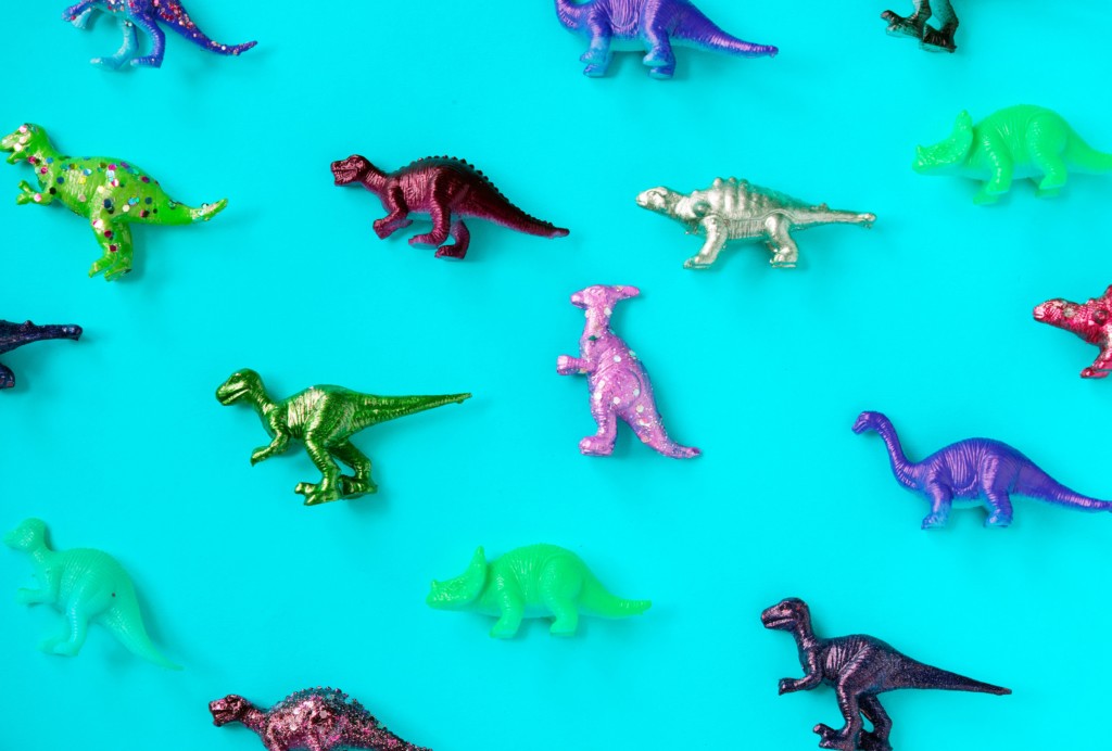 blue background with multi-colored toy dinosaurs 