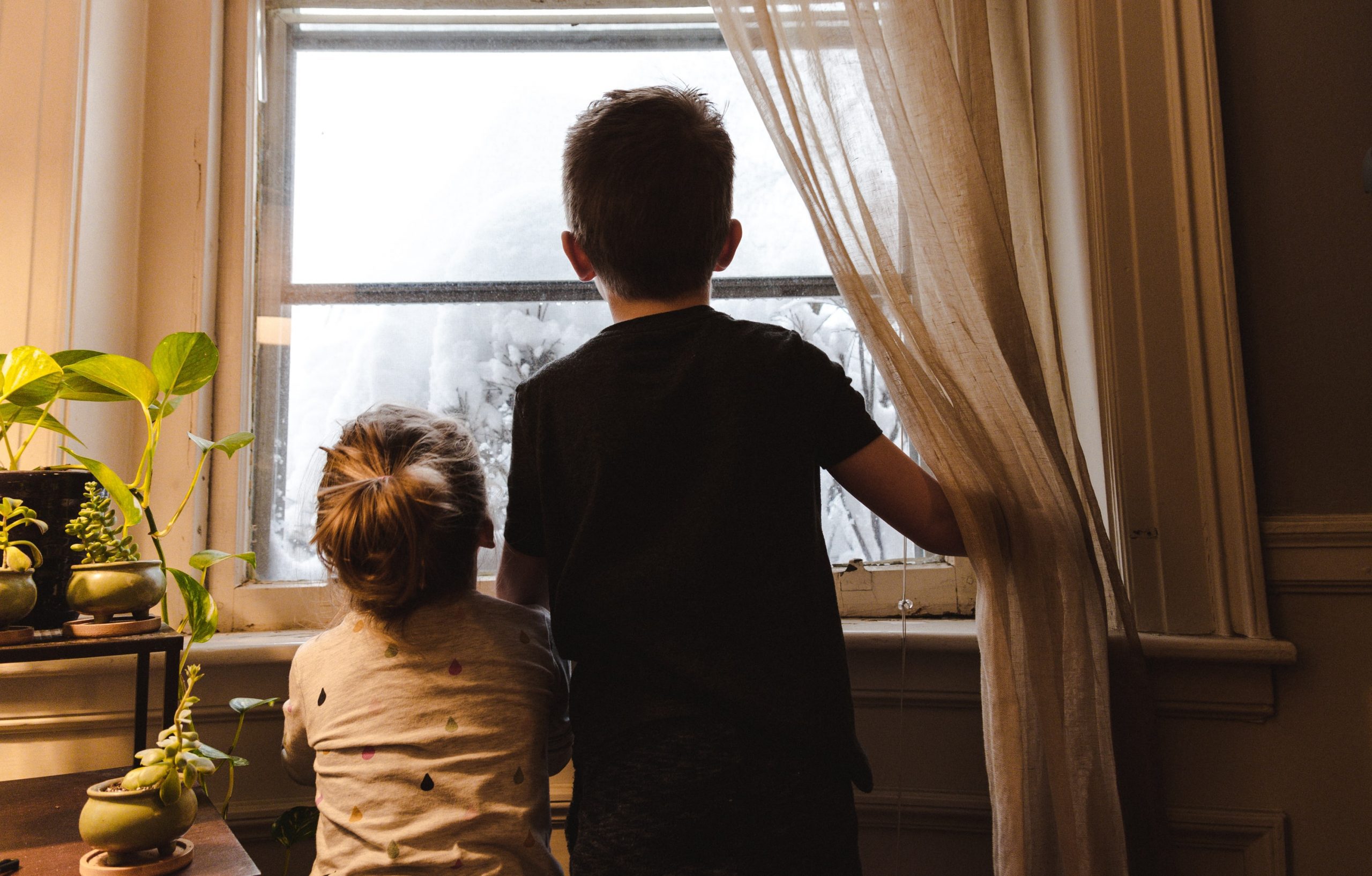two children looking out window