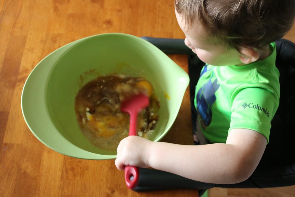 A small child helps mix pie filling