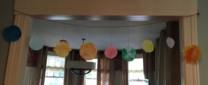 Coffee filters painted and cut to look like the planets in our solar system, strung up in order on a string