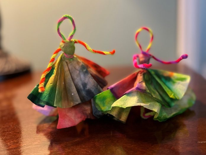 Colorful pipe cleaners and coffee filter papers twisted together to look like dancing ladies