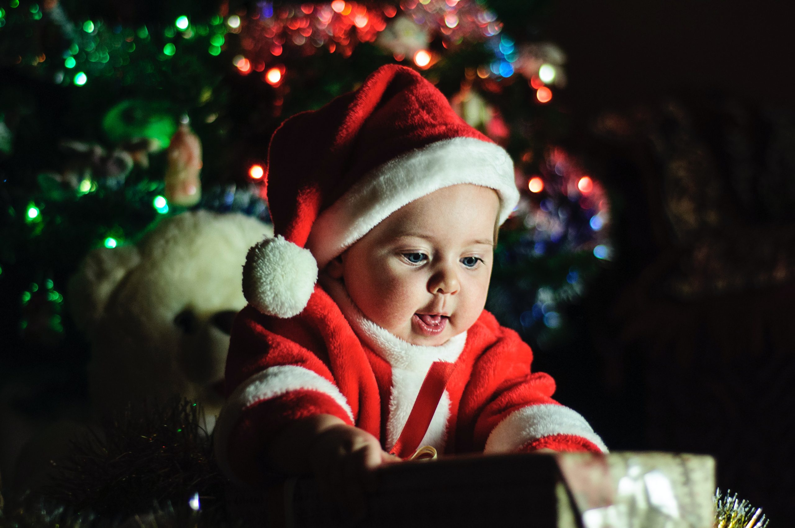 happy toddler dressed in Santa hat