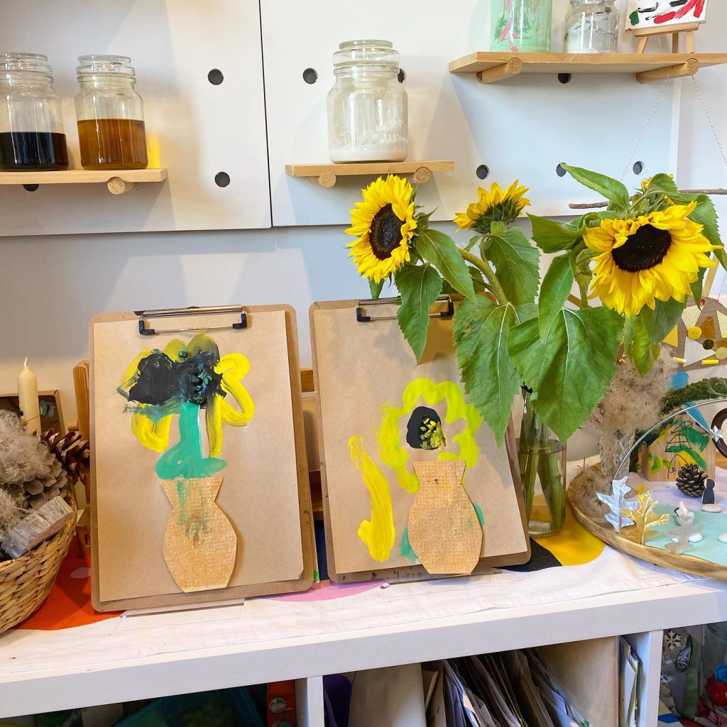 Sunflower art on tabletop easels and flowers in a vase