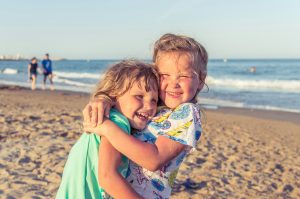 two girls hugging on beach