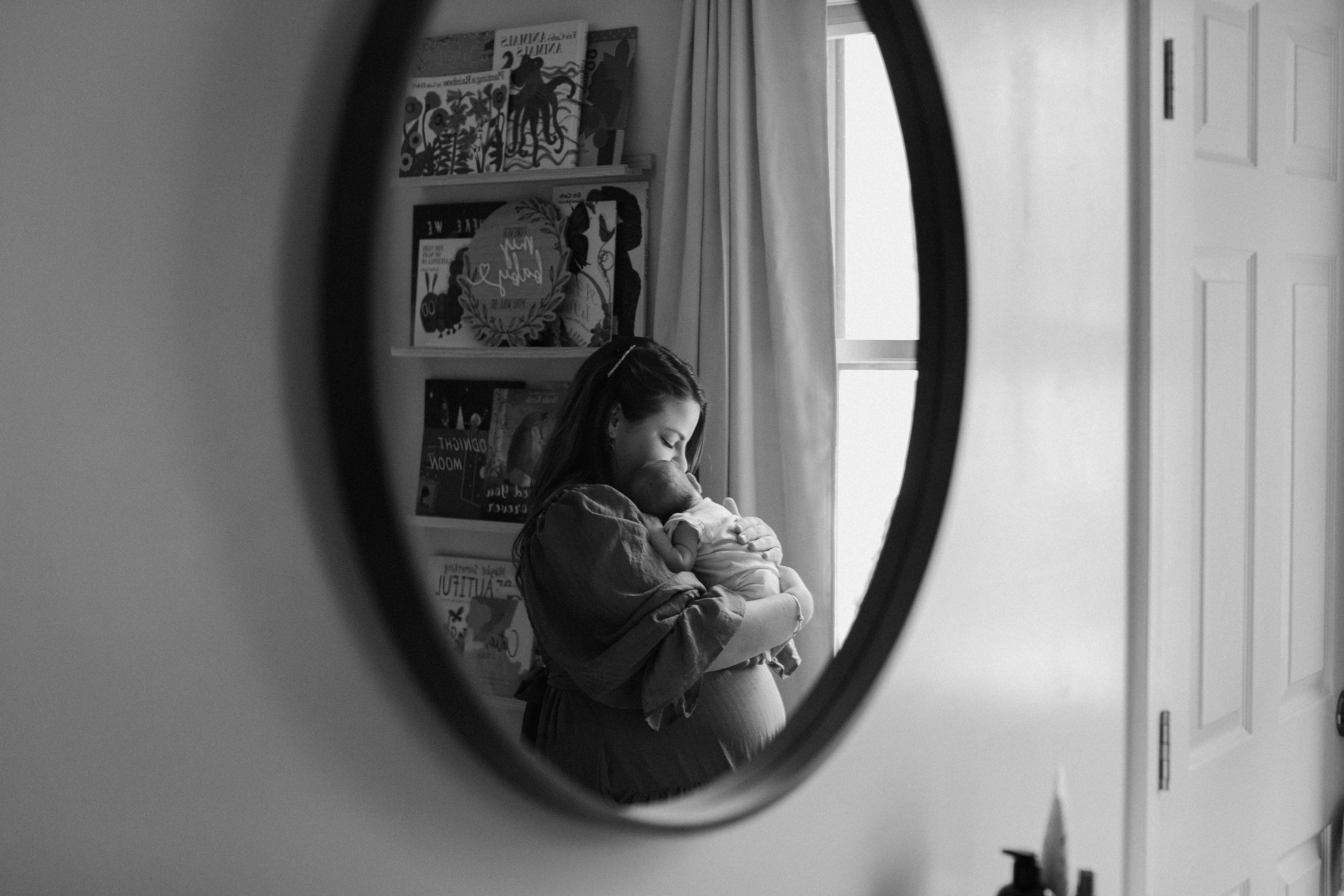 Mother and newborn daughter in the mirror 